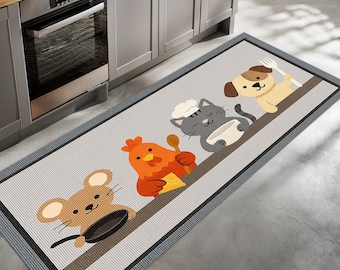 May include: A rectangular kitchen mat featuring cartoon animals in chef hats. The design includes a mouse with a pan, a chicken with a spoon, a cat with a bowl, and a dog with a fork. The mat has a gray background with a dark border.