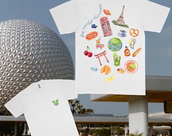 May include: Two white t-shirts. The front of one t-shirt has a green Mickey Mouse head in the pocket. The back of the other t-shirt has a colorful design with the text "the world showcase".