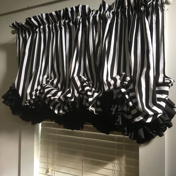 Cortina de globos a rayas en blanco y negro con volantes dobles negros