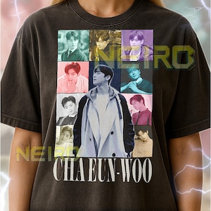 May include: Dark grey unisex t-shirt with a grid of nine images of a person, and the name "CHAEUN-WOO" in white. Text at the bottom provides sizing information. The shirt is worn by a person.