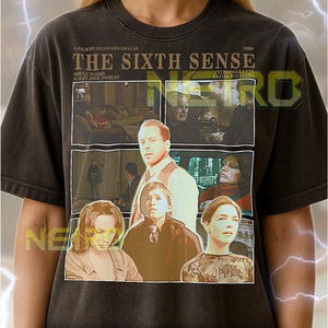 Op de afbeelding: Donkergrijs unisex T-shirt met een filmposterontwerp voor "The Sixth Sense" met Bruce Willis. De afbeelding bevat filmstills en tekst. Het shirt heeft een ronde hals.