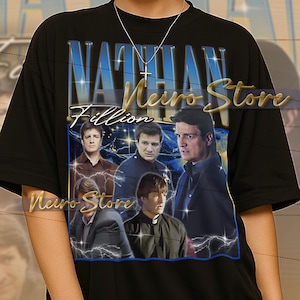 May include: Black t-shirt with a graphic of Nathan Fillion and the text "Nathan Fillion" and "Naro Store". The graphic includes images of Fillion in various roles. The shirt is a unisex style.