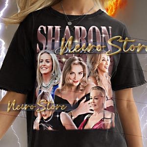 May include: Black t-shirt featuring the text "SHARON Stone" in a gold script, with images of Sharon Stone. The shirt has a distressed look. The background has a fiery design.