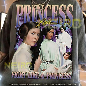 May include: Dark gray unisex t-shirt featuring a graphic of Princess Leia with the text "PRINCESS Leia" and "FIGHT LIKE A PRINCESS". The design includes images of the character in various poses. The shirt is a XL size.