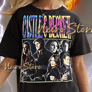 May include: Black t-shirt with a graphic of the "Castle" TV show cast and the text "CASTLE & BECKETT" in a colourful, iridescent font. The shirt is worn by a person with blonde hair.