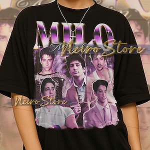 May include: Black unisex t-shirt with a purple and gold "MILO" design and the text "Neiro Store". The shirt features a group of young men. The model is wearing an XL shirt. The shirt is true to size.