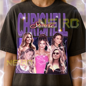 May include: Dark gray unisex t-shirt featuring a graphic of the name "Chrishell Stause" with a photo collage of women. The text "CHRICHEIRO" is above the name. The shirt has a vintage look.