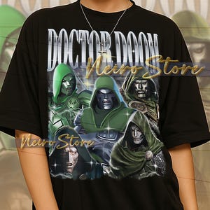 May include: Black t-shirt featuring a graphic of Doctor Doom with the text "DOCTOR DOOM" in a silver font. The graphic includes multiple images of Doctor Doom in green and silver. The shirt is a unisex style.