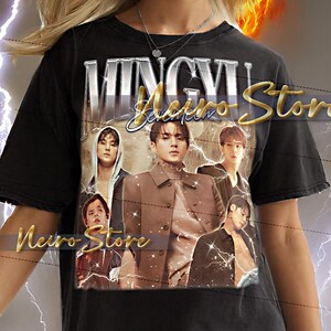 May include: Black t-shirt featuring a graphic of a group of people with the text "MINGYU Seventeen Store" and "Neuro Store". The shirt is worn by a person with blonde hair.