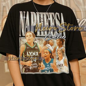 May include: Black t-shirt featuring a graphic of a basketball team with the text "NAPHEESA Collier" in silver. The team is wearing green, blue, and white jerseys. The shirt also has the text "MINNESOTA LYNX" and "MAYO CLINIC".