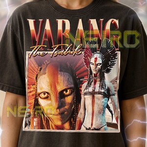 May include: Dark gray unisex t-shirt featuring a graphic from the movie "Avatar: The Way of Water". The design includes the text "VARANG The Tsahik" in a stylized font, along with two character portraits. The shirt is a vintage style.