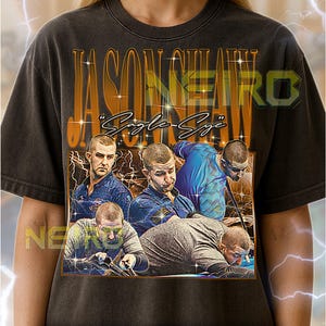 May include: Dark gray unisex t-shirt featuring a graphic design with the text "JASON NEIRO" and "Eagle-Eye". The design includes images of men in various poses. The shirt is a vintage style.