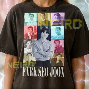 Könnte beinhalten: Dunkelgraues Unisex-T-Shirt mit einem Raster aus neun Bildern von Park Seo-Joon, mit dem Namen "PARK SEO-JOON" in weißen Blockbuchstaben darunter. Das Shirt hat einen Vintage-Look.