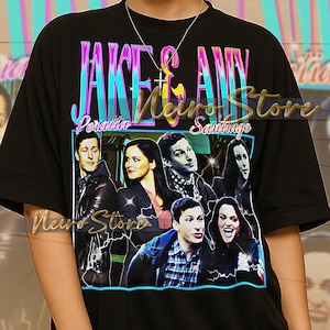 May include: Black t-shirt with a graphic design featuring the text "Jake & Amy Peralta Santiago" and images of characters. The shirt has a crew neck and short sleeves. The shirt is unisex.