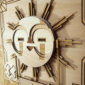 Peut inclure: Une œuvre d'art en bois multicouche représentant un soleil avec des rayons géométriques et un visage stylisé. L'œuvre est principalement marron clair avec des accents dorés, sur un fond en bois marron clair. Le style est Art Déco.