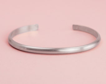 May include: A silver bangle bracelet with a smooth, polished finish.