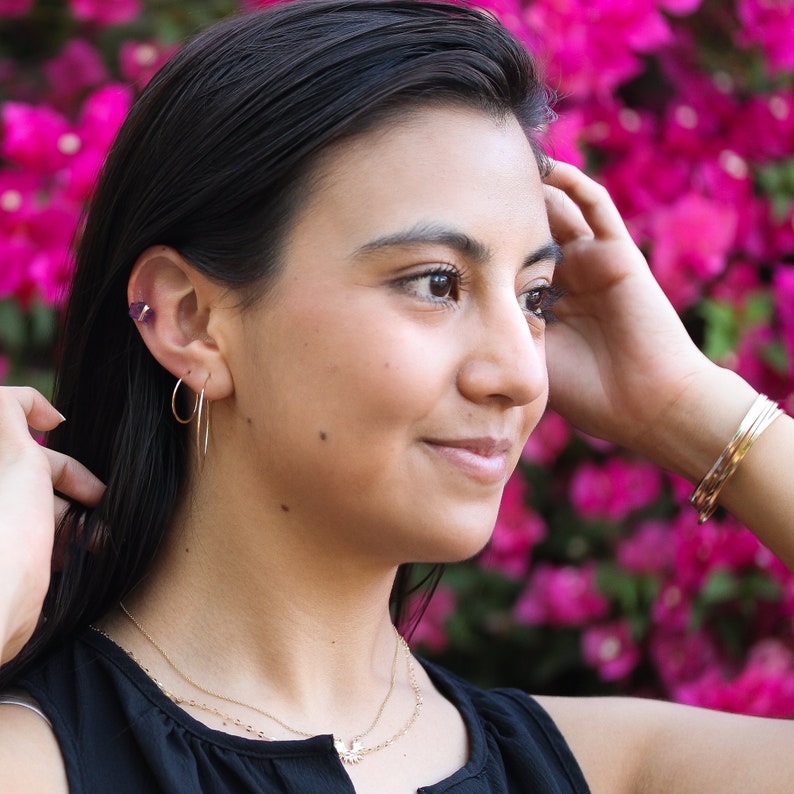 Ensemble of mixed metal square Cuffs with a twist by Lotus Stone Jewelry on model. Cuffs are in rose gold, yellow gold, and sterling silver