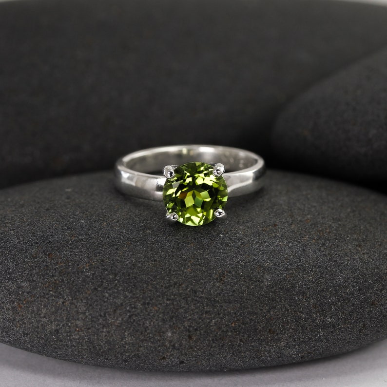 Solid sterling silver peridot gemstone ring by Lotus Stone Jewelry on black stones