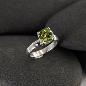 Solid sterling silver peridot gemstone ring by Lotus Stone Jewelry on black stones