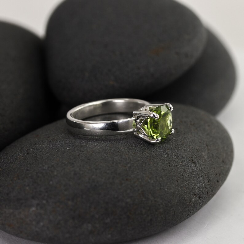 Solid sterling silver peridot gemstone ring by Lotus Stone Jewelry on black stones