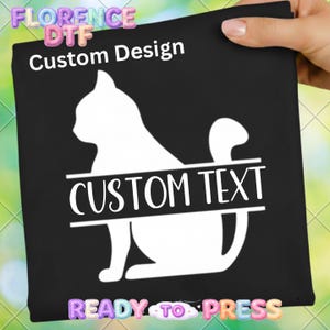 May include: Black square with a white cat silhouette design and the words "Custom Design" and "Custom Text". The words "Ready to Press" are at the bottom. The image is held by a hand.