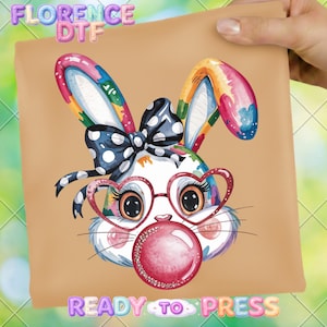 May include: A colorful bunny graphic with heart-shaped glasses and a bubblegum bubble. The bunny has a polka dot bow and rainbow-colored ears. The text "READY TO PRESS" is at the bottom, and "FLORENCE DTF" is at the top.