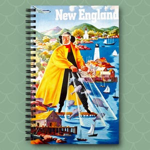 May include: Spiral-bound notebook featuring a vintage travel poster design for New England. The artwork depicts a fisherman in a yellow coat pulling a net filled with fish, with a coastal town and lighthouse in the background. The words "New England" are at the top.
