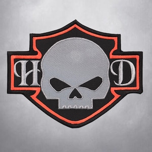 Può includere: Toppa ricamata nera e arancione con un designo di teschio e ossa incrociate. Il teschio è grigio e le ossa incrociate sono contornate di bianco. Le lettere "HD" sono ricamate in bianco sulle ossa incrociate.