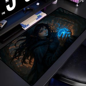 Może przedstawiać: Prostokątna podkładka pod mysz do gier z fantastycznym projektem artystycznym. Grafika przedstawia kobietę z długimi czarnymi włosami trzymającą świecącą niebieską kulę. Tło przedstawia ciemny las z pomarańczowymi i niebieskimi odcieniami.