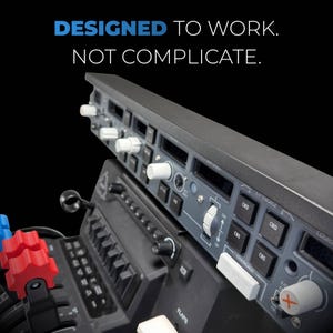 May include: A detailed view of an aircraft control panel in shades of grey and black, featuring white knobs and buttons. The text reads "DESIGNED TO WORK. NOT COMPLICATE." The panel includes various switches and dials.