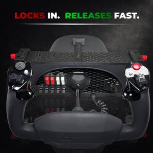 May include: Black flight simulator control panel with red and white switches, joysticks, and the text "LOCKS IN. RELEASES FAST." The panel has a central control stick and is designed for flight simulation.