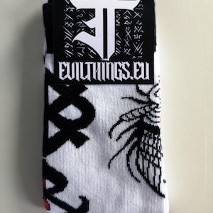 May include: A pair of white socks with black and red designs. The socks feature a black and white graphic of a dragon and the text "Evil Things.eu".