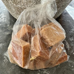 K&ouml;nnte beinhalten: Eine durchsichtige Plastikt&uuml;te gef&uuml;llt mit mehreren braunen Zuckerw&uuml;rfeln.