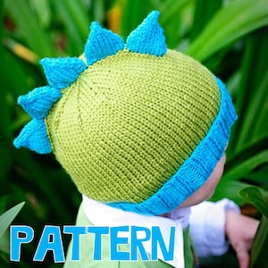 May include: A knitted dinosaur hat in shades of green and blue. The hat features a light green body with blue trim and matching spikes along the top. The word "PATTERN" is visible in the lower left corner.