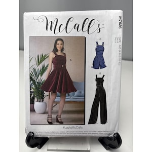 May include: A McCall's sewing pattern package featuring a woman in a burgundy dress and illustrations of two other garment options. The package includes the text "#LaylaMcCalls" and size information.