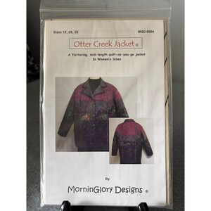 Op de afbeelding: Een naaipatroon voor de "Otter Creek Jacket" in de maten 1X, 2X en 3X. De patroonhoes toont een gewatteerde jas in paars, roze en groen. De tekst op de hoes luidt "A flattering, mid-length quilt-as-you-go jacket".