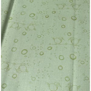 May include: Light green fabric with a repeating pattern of birds perched on branches and scattered circles. The birds and circles are in a lighter shade of green, creating a subtle, textured design.