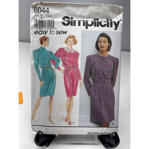 May include: Simplicity sewing pattern 8044, size Y (18-22). The pattern features illustrations of three dresses. The text "easy to sew" is printed on the pattern. The pattern is displayed on a white background.