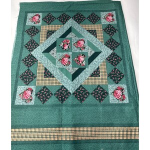 May include: A rectangular fabric panel featuring a central diamond pattern composed of green floral and plaid sections. The design includes four heart-shaped motifs with pink rose prints in the center and four more at the corners, surrounded by dark green diamond-shaped accents and a plaid border.
