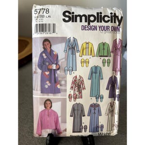 May include: A Simplicity sewing pattern for robes and loungewear. The pattern features illustrations of various robe designs, including a purple robe with floral embroidery, and the text "DESIGN YOUR OWN 12 greatlooks".
