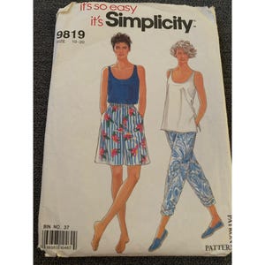 May include: Simplicity sewing pattern number 9819 for sizes 10-20. The pattern includes instructions for making two garments: a sleeveless top and a pair of shorts. The model on the left is wearing a blue sleeveless top and floral print shorts. The model on the right is wearing a white sleeveless top and blue and white patterned pants.