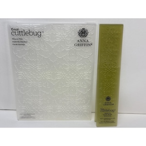 May include: Two crafting tools: a clear, embossed plastic plate with a thistle pattern and the text "Cricut cuttlebug", and a green rectangular plate with a thistle pattern. The Anna Griffin brand logo is visible.