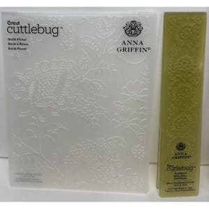 May include: A clear, embossed Cricut Cuttlebug embossing folder and a green rectangular embossing folder. The larger folder features a floral batik design with the text "Batik Floral" and "Anna Griffin". The smaller folder also has a floral design.