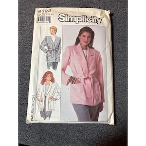 May include: A Simplicity pattern envelope featuring illustrations of belted blazers. The main image showcases a pink blazer with a tie belt and pockets. The envelope includes the text "Simplicity" and pattern details.