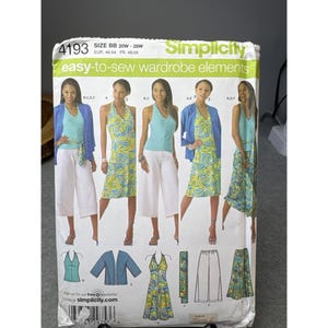 Puede incluir: Un patrón de costura Simplicity para elementos de vestuario fáciles de coser. El patrón presenta varias combinaciones de atuendos, incluyendo tops, chaquetas y faldas. El rango de tallas es BB 20W-28W, EUR 46-54 y FR 48-56. El patrón incluye el texto "Simplicity" y "easy-to-sew wardrobe elements."