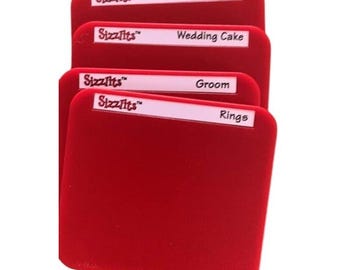 May include: Four red, square wedding accessories with white labels. The labels read "Bride", "Wedding Cake", "Groom", and "Rings". The brand name "Sizzlits" is printed on each label.