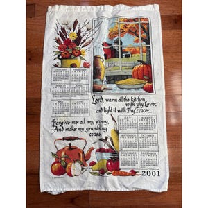 May include: A white ceramic mug with a black handle and the text "But First, Coffee" in a bold, black font. The mug is set against a blurred background, suggesting a cozy setting.