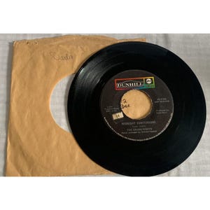 May include: A black vinyl record with the title "Midnight Confessions" by The Grass Roots, in a brown paper sleeve. The record label features the Dunhill logo and the text "Darla" is written on the sleeve.
