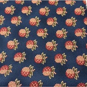 May include: Close-up of a navy blue fabric with a repeating pattern of stylized raspberries. The raspberries are a mix of red and pink, with green leaves and stems. The design is evenly spaced across the fabric.