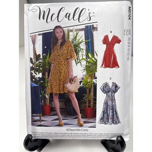 May include: McCall's sewing pattern M8104 featuring a woman in a yellow dress with a black dot pattern. The pattern includes multiple view options with simple instructions. The size is A5 (6-8-10-12-14).